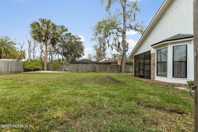 view of yard featuring a fenced backyard and a sunroom