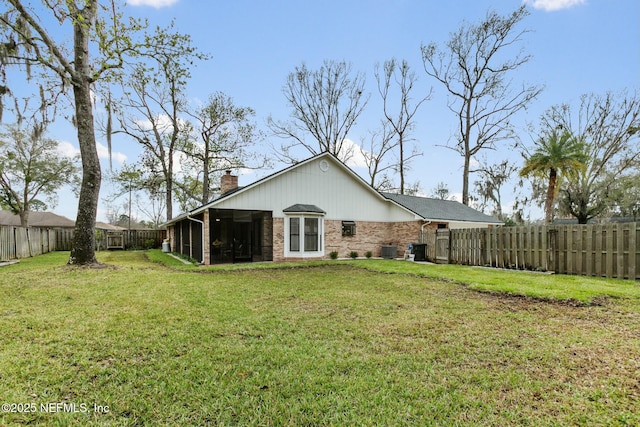 back of house featuring a fenced backyard, a lawn, and a chimney