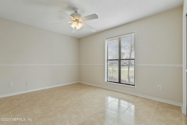 unfurnished room with ceiling fan, light tile patterned floors, a textured ceiling, and baseboards