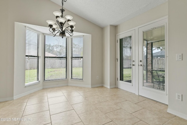 unfurnished dining area featuring tile patterned flooring, vaulted ceiling, a textured ceiling, french doors, and a notable chandelier