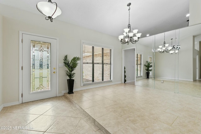 foyer entrance with light tile patterned floors, baseboards, and a notable chandelier