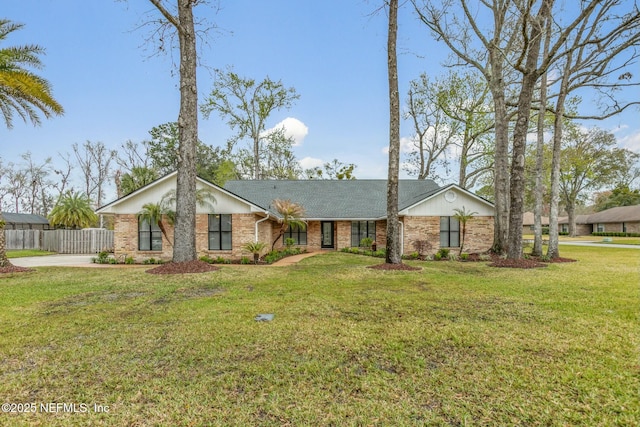 mid-century home featuring a front yard, fence, and brick siding