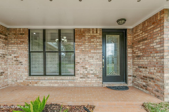 property entrance featuring brick siding