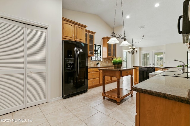 kitchen featuring light tile patterned floors, lofted ceiling, brown cabinetry, a sink, and black appliances