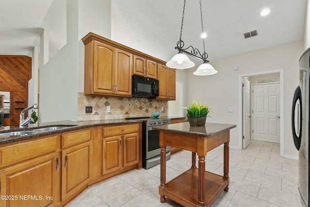 kitchen with black microwave, refrigerator, a sink, visible vents, and electric stove