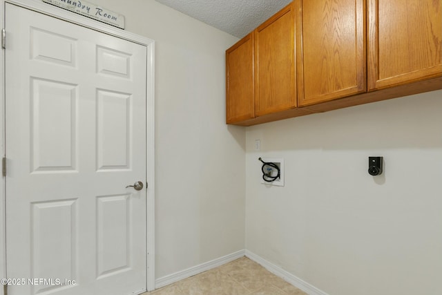 clothes washing area featuring cabinet space, light tile patterned floors, baseboards, hookup for a washing machine, and a textured ceiling