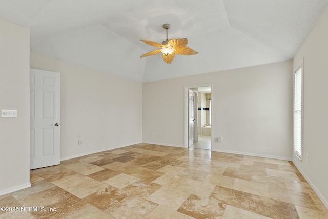 unfurnished room with a ceiling fan, lofted ceiling, and baseboards