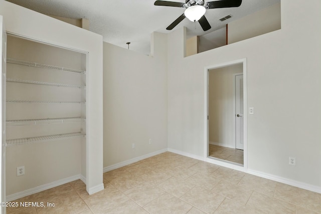 unfurnished bedroom featuring a closet, visible vents, ceiling fan, baseboards, and tile patterned floors