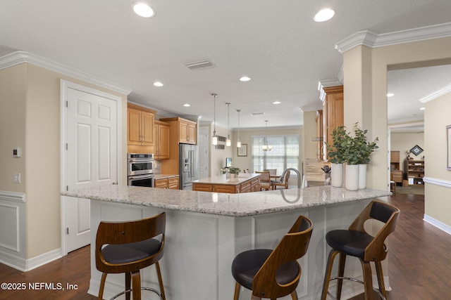 607 Caspia Ln, Ponte Vedra, FL 32081 - kitchen featuring a kitchen bar, a kitchen island, stainless steel appliances, and dark wood finished floors