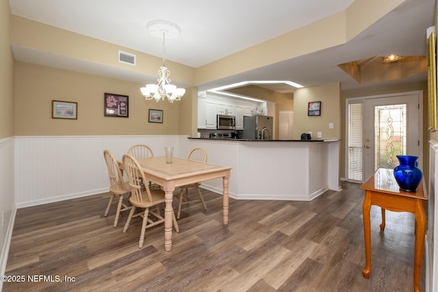 4020 Lavista Cir Unit 207, Jacksonville, FL 32217 - dining area featuring visible vents, a chandelier, wood finished floors, and wainscoting