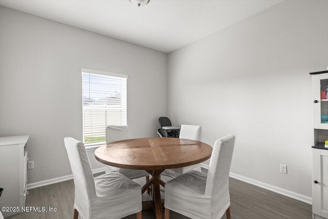 dining room featuring baseboards and wood finished floors