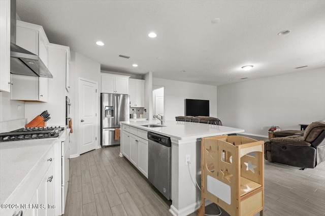 kitchen with an island with sink, stainless steel appliances, a sink, and open floor plan