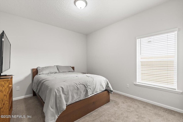 carpeted bedroom featuring a textured ceiling and baseboards