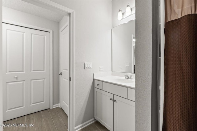 bathroom with wood tiled floor, vanity, and baseboards