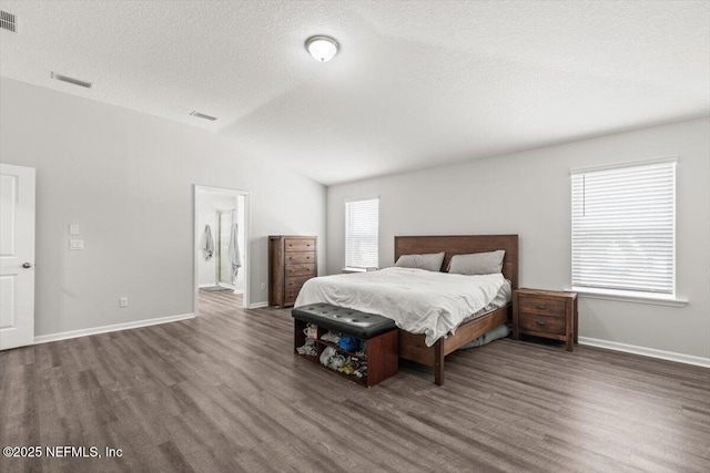 bedroom with lofted ceiling, wood finished floors, and visible vents