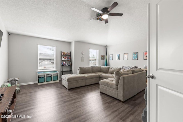 living area featuring ceiling fan, baseboards, dark wood finished floors, and a textured ceiling