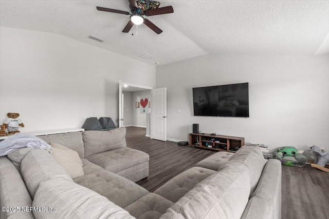 living area featuring visible vents, a ceiling fan, wood finished floors, vaulted ceiling, and a textured ceiling