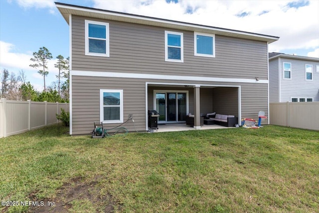 back of property with a patio area, a fenced backyard, a yard, and an outdoor living space