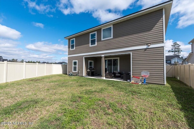 rear view of house with a fenced backyard, a lawn, and a patio