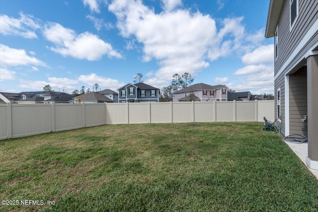 view of yard with a fenced backyard and a residential view