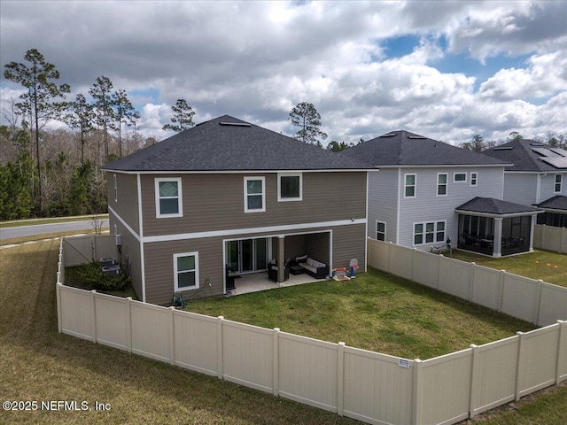 back of house featuring a patio area, a lawn, a fenced backyard, and roof with shingles