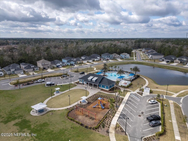 birds eye view of property with a water view and a wooded view