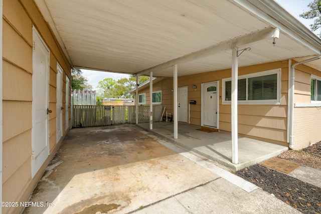 view of patio / terrace with an attached carport and fence