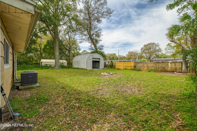 view of yard with fence private yard, cooling unit, and an outbuilding