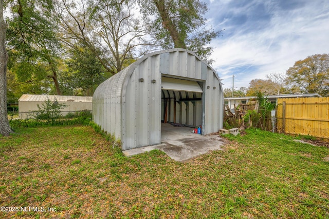 view of outdoor structure featuring an outbuilding and fence