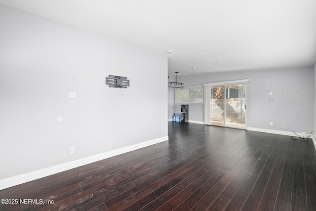 unfurnished living room with baseboards and wood finished floors