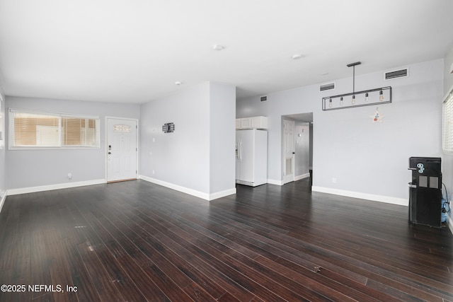 unfurnished living room with baseboards, visible vents, and dark wood-style flooring