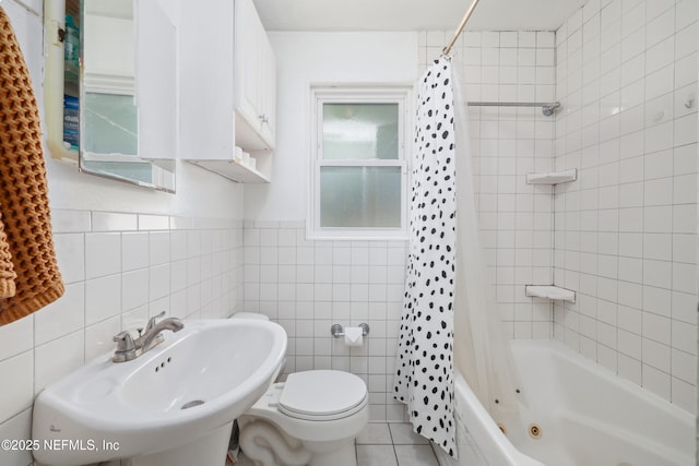 full bathroom featuring tile walls, shower / bathtub combination with curtain, toilet, a sink, and tile patterned floors