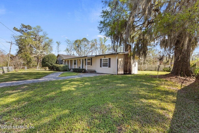 view of front of property featuring a chimney, a front yard, and fence