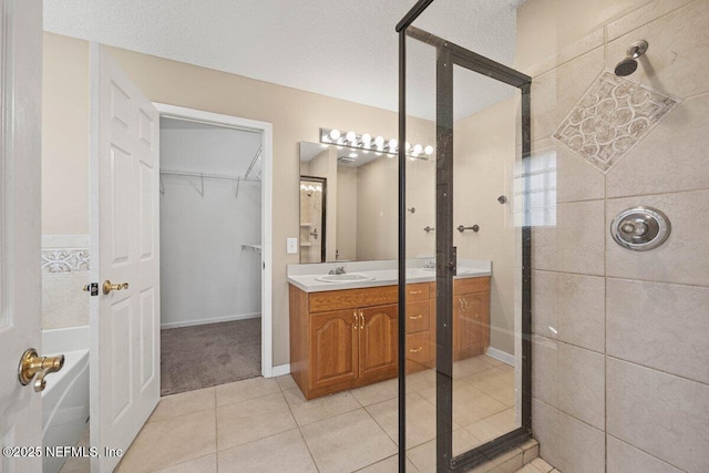 full bathroom with vanity, tile patterned floors, and a tile shower