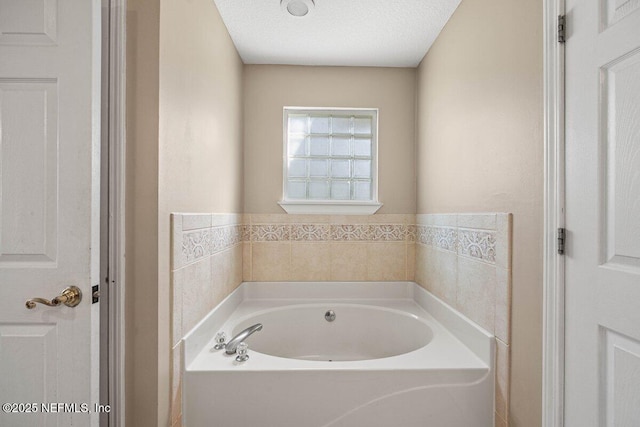 bathroom featuring a textured ceiling and a garden tub