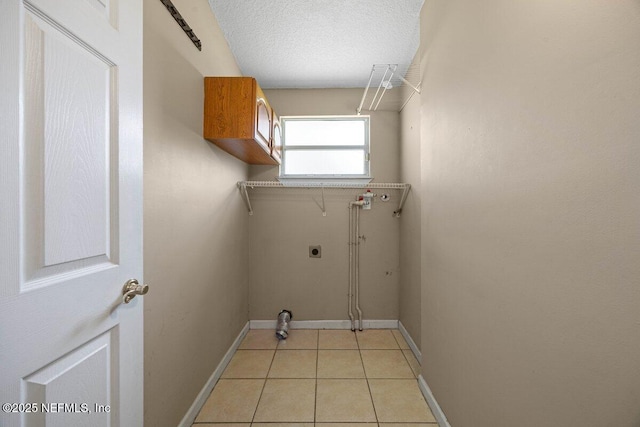 laundry area featuring a textured ceiling, light tile patterned floors, baseboards, hookup for an electric dryer, and laundry area