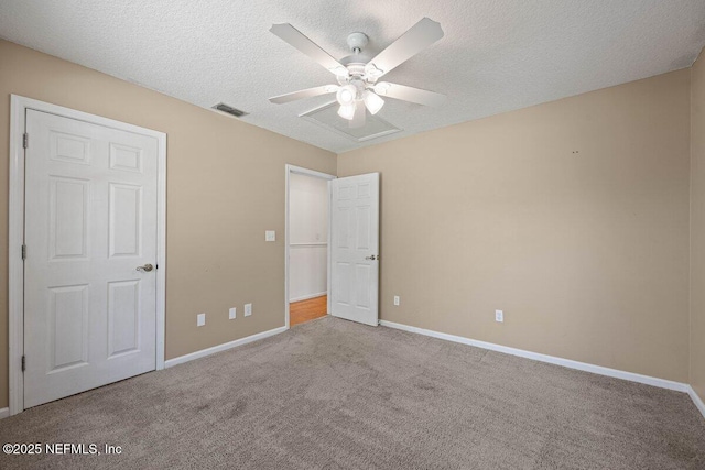 unfurnished bedroom with visible vents, carpet flooring, a textured ceiling, and baseboards