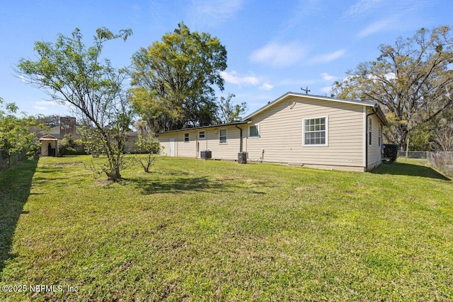 back of house featuring central air condition unit, a yard, and fence