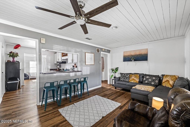 living area featuring wooden ceiling, ornamental molding, and dark wood finished floors