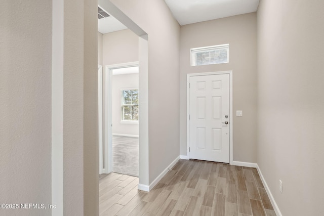 foyer featuring light wood-style flooring, visible vents, and baseboards