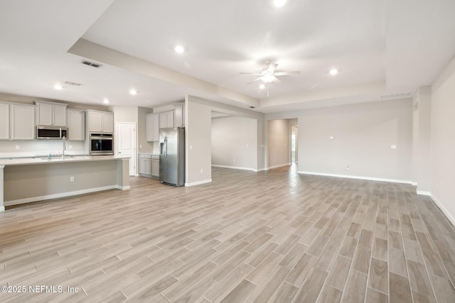 unfurnished living room with light wood-style floors, ceiling fan, baseboards, and recessed lighting