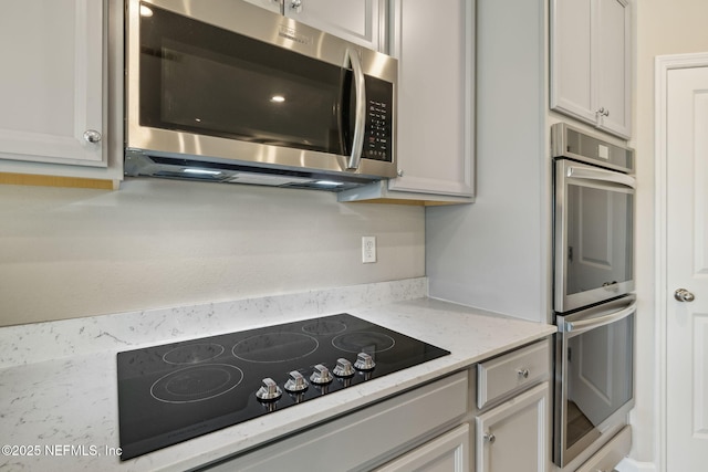 kitchen featuring stainless steel appliances and light stone counters