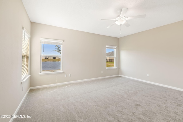 spare room with a ceiling fan, carpet, and baseboards