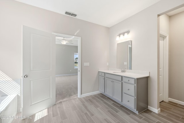 bathroom featuring wood finish floors, vanity, visible vents, and baseboards