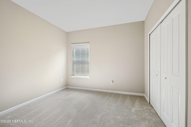 unfurnished bedroom with a closet, carpet flooring, and baseboards