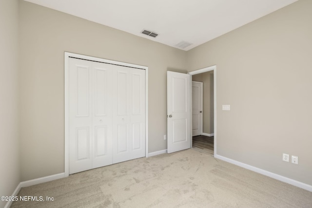 unfurnished bedroom featuring a closet, carpet, visible vents, and baseboards