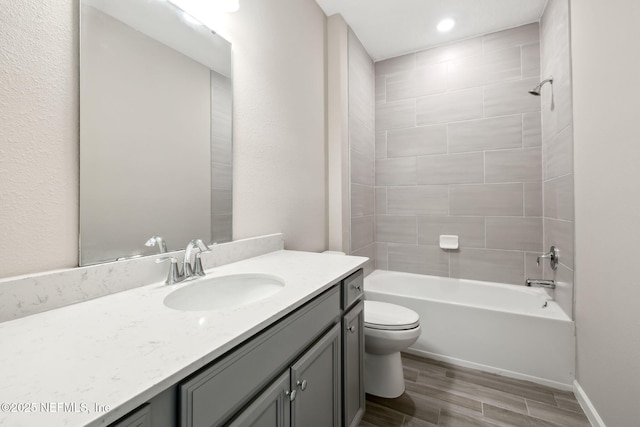 full bath featuring wood finished floors, shower / bathing tub combination, vanity, and toilet