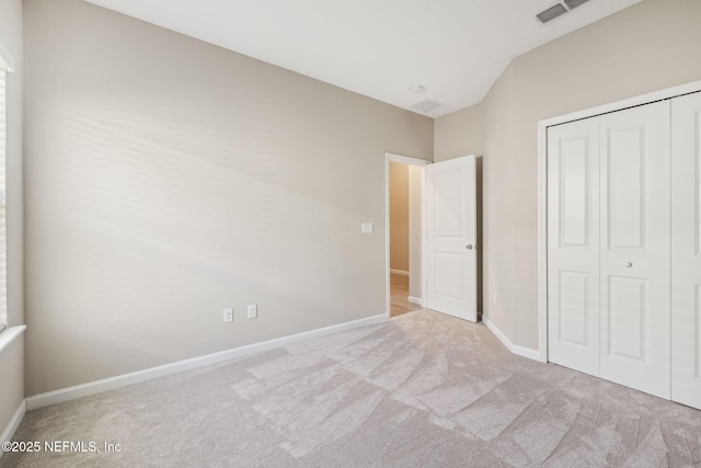 unfurnished bedroom featuring a closet, carpet, visible vents, and baseboards