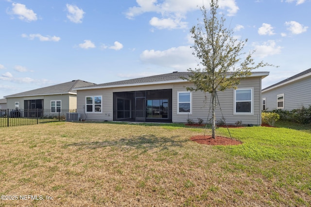 back of property with central AC unit, a lawn, fence, and a sunroom