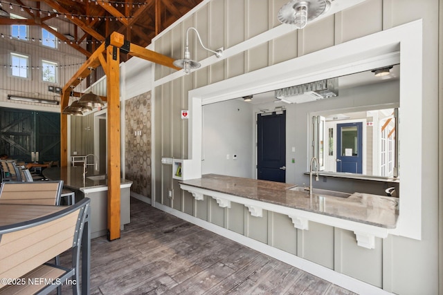 bathroom with wood finished floors, a sink, and a towering ceiling